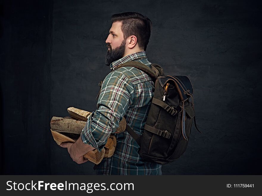 Middle Age Male Holds Backpack And Firewoods.