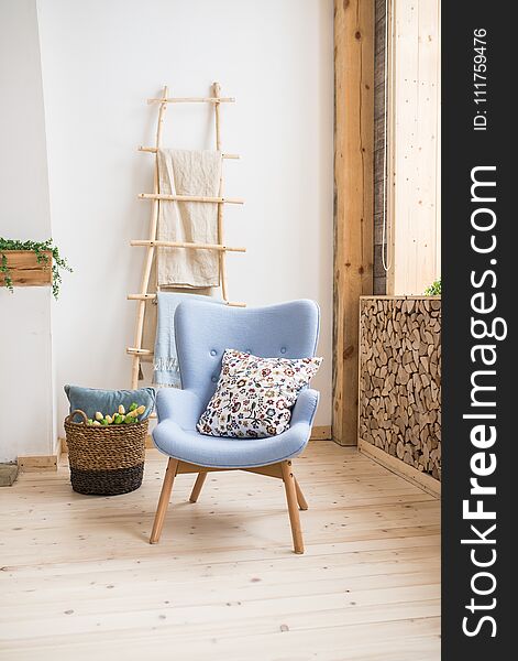 Interior Of Scandinavian Room. Blue Armchair With A Pillow On Them, A Wooden Staircase With A Towel Hanging On It, Basket With Tu