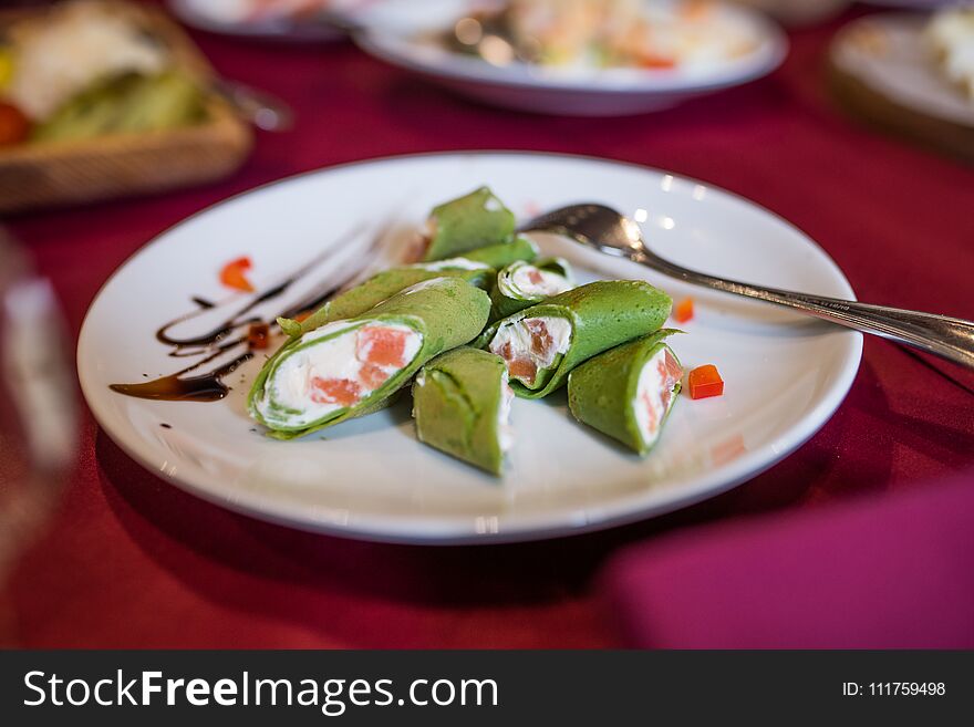 Green Pancakes. Pancakes With Spinach Stuffed With Cream Cheese And Fish On A White Plate.