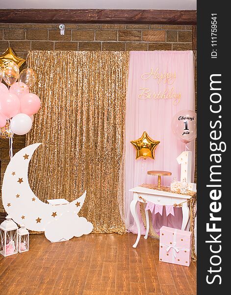 Children`s photo zone with a wooden month with stars and a lot of balloons. Decorations for a One year old Girl’s Birthday .