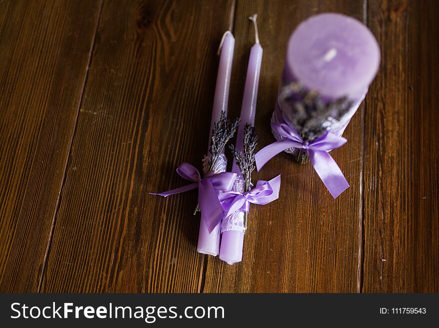 Three Purple Candles Decorated With Lavender Branches.