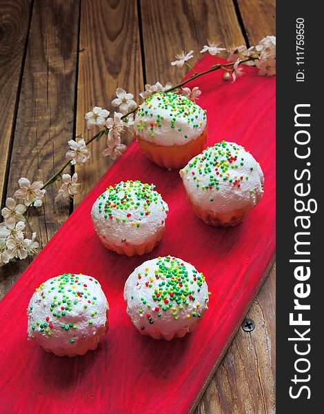 Easter colorful cupcakes on wooden table. Easter cupcakes and a cherry twig