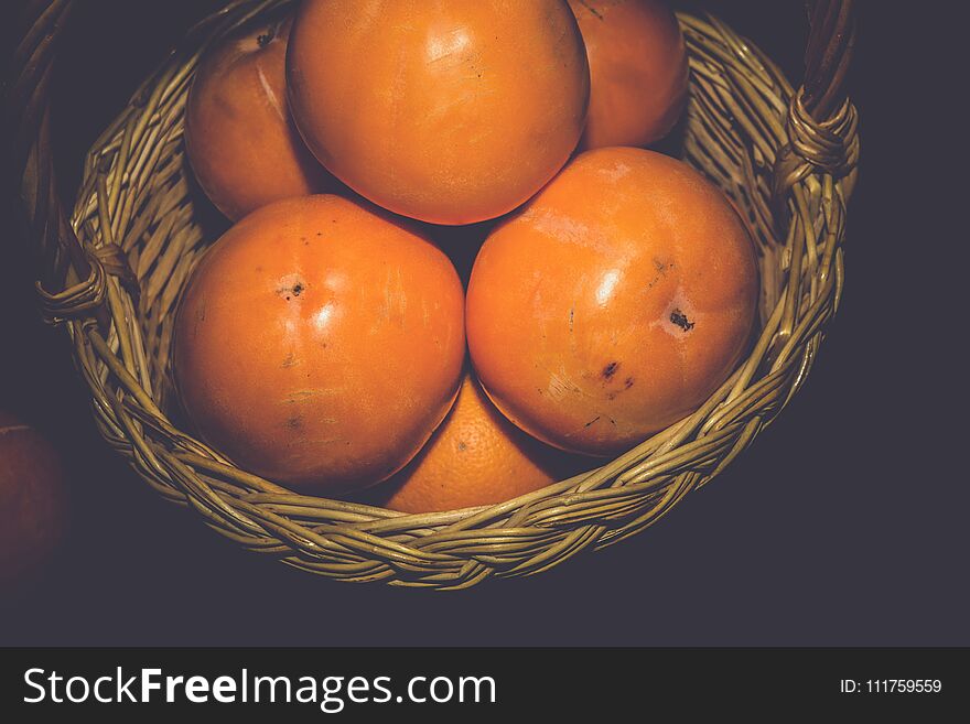 Delicious ripe persimmon, juicy orange fruits on black background, filtered. Delicious ripe persimmon, juicy orange fruits on black background, filtered.