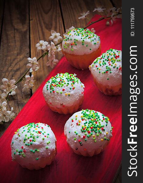 Easter colorful cupcakes on wooden table. Easter cupcakes and a cherry twig