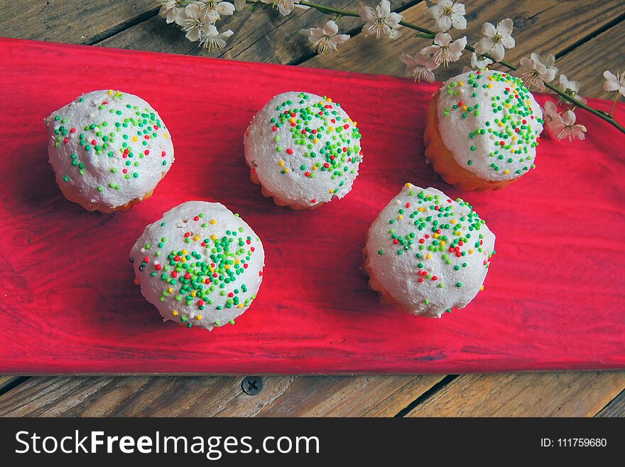 Easter colorful cupcakes on wooden table. Easter cupcakes and a cherry twig