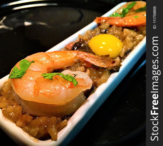 Seafood Risotto topped with with Scampi Prawns, and a raw quail-egg appetizer. Seafood Risotto topped with with Scampi Prawns, and a raw quail-egg appetizer