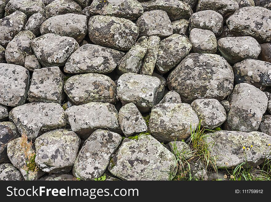 The stones lie in a pile covered with moss and lichen in close-up. The boulders and cobbles.