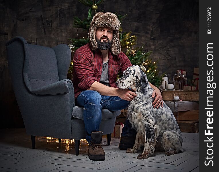 A man in fur hat and Irish setter dog.