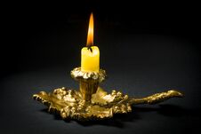 Vintage Candlestick With A Lit Candle On A Black Background Stock Image