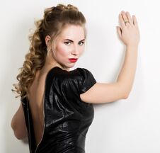 Beautiful Young Woman Wearing Short Leather Black Dress With Naked Back On A Light Background Royalty Free Stock Photo
