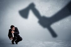 Businessman Afraid Of A Huge Shadow Hand Holding An Axe Concept Stock Photo