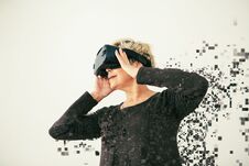 An Elderly Woman In Virtual Reality Glasses Is Scattered By Pixels. Conceptual Photography With Visual Effects With An Stock Image