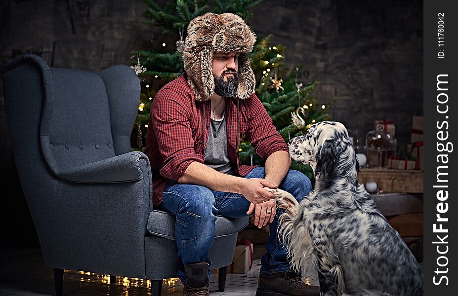 A man in fur hat and Irish setter dog.