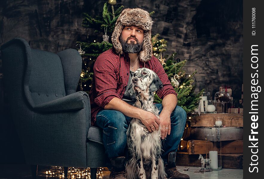 A man in fur hat and Irish setter dog.
