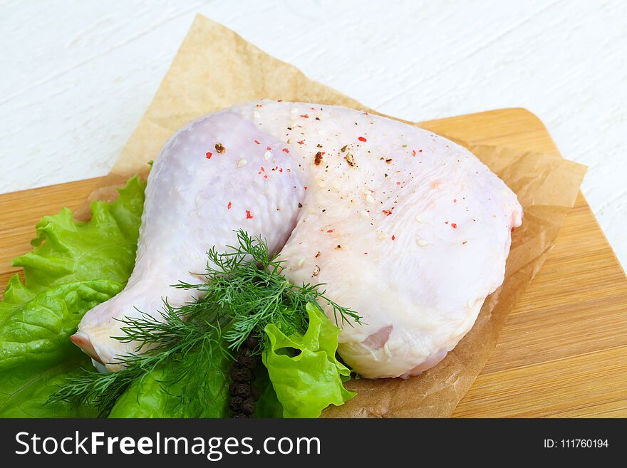 Raw chicken leg with herbs and spices ready for cooking