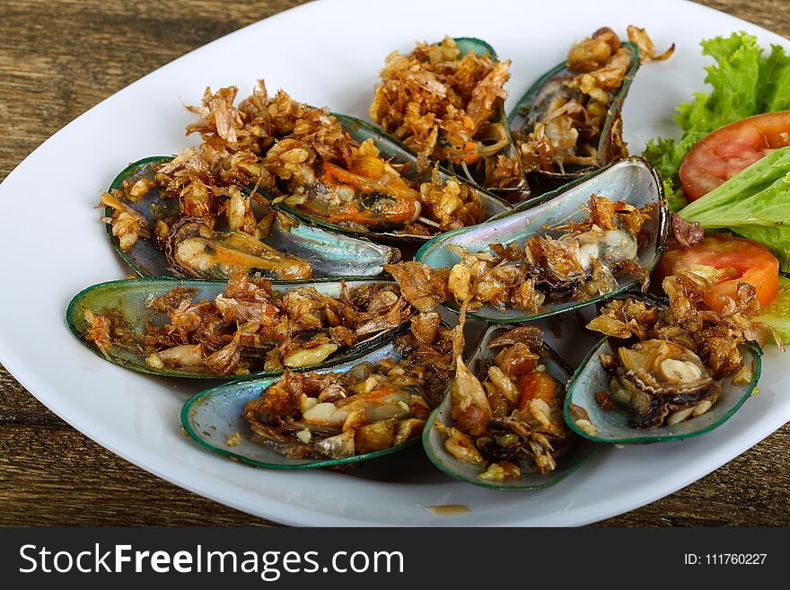 Fresh Mussels with fried garlic served tomato, salad and cucumber. Fresh Mussels with fried garlic served tomato, salad and cucumber
