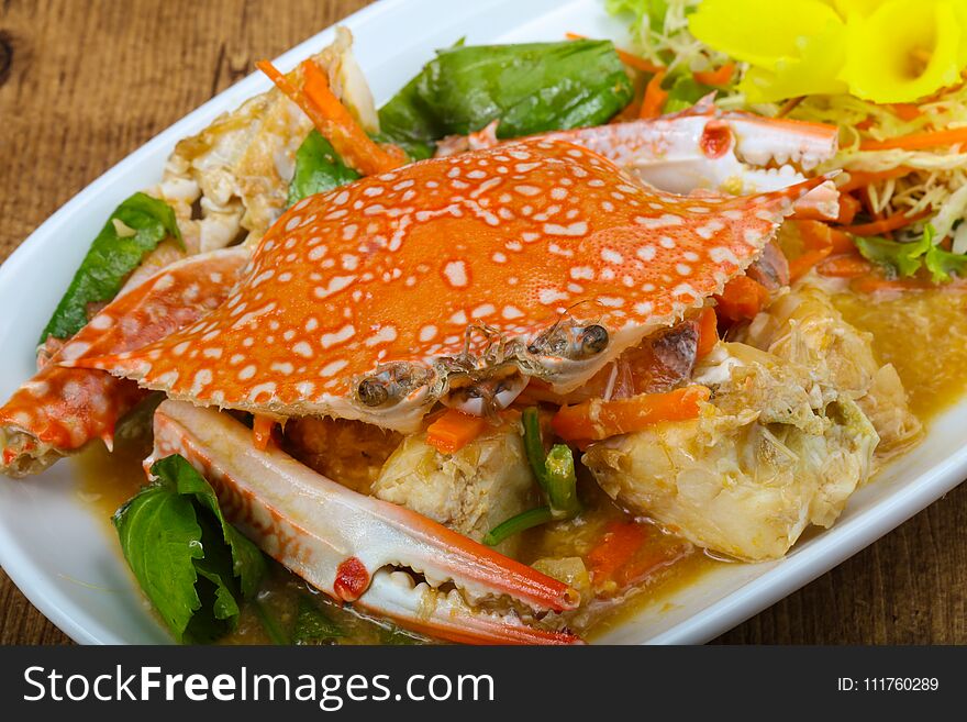 Boiled crab with sauce on wood background