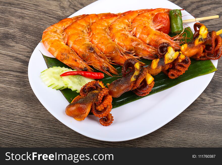 Skewer with octopus and prawn on banana leaves