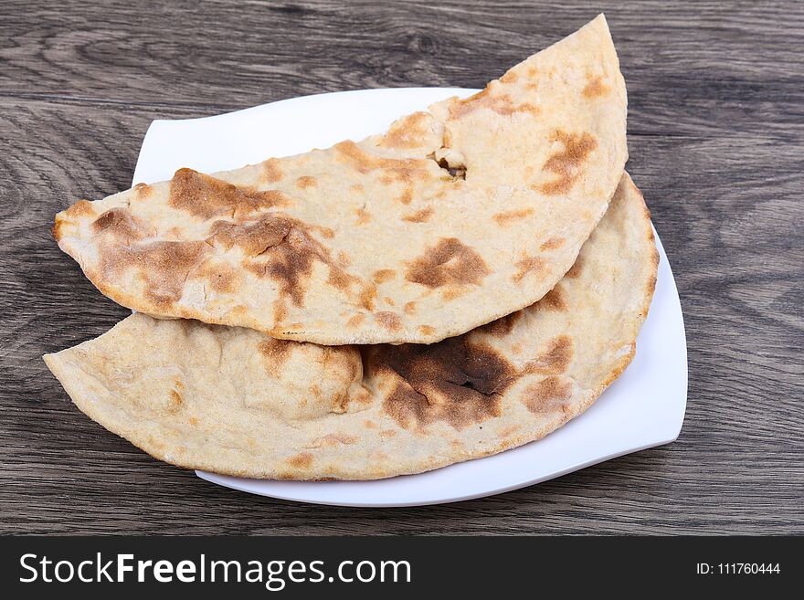 Indian bread naan in the plate on wood background