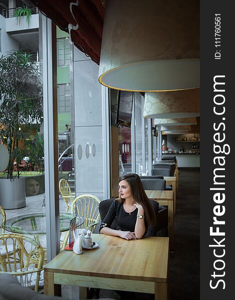 Girl looking out window in cafe