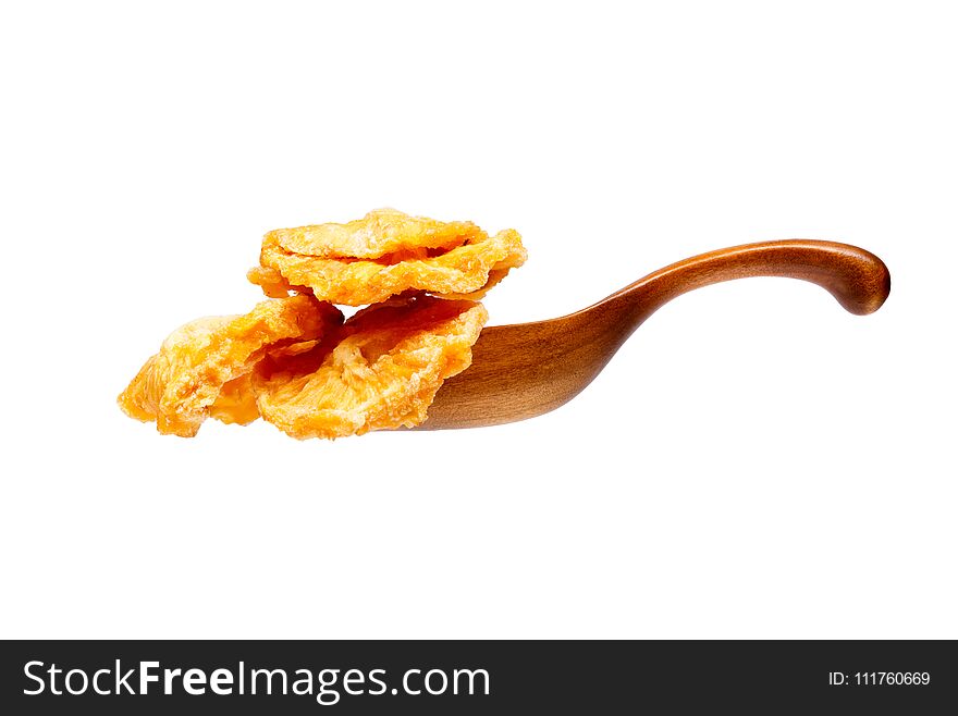 Dried pineapples slices in the wooden spoon, isolated on white background.