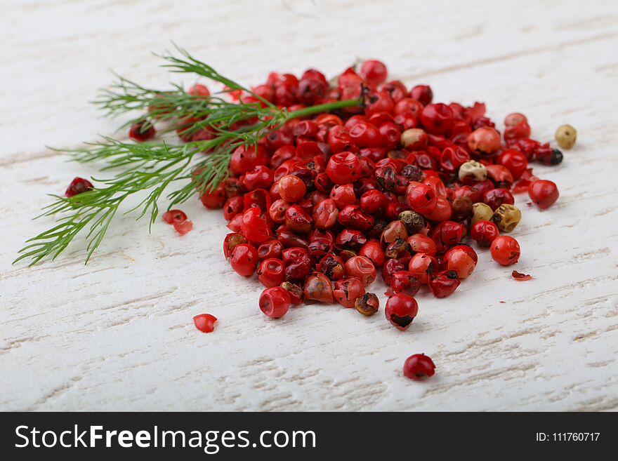 Red pepper corn on the wood background