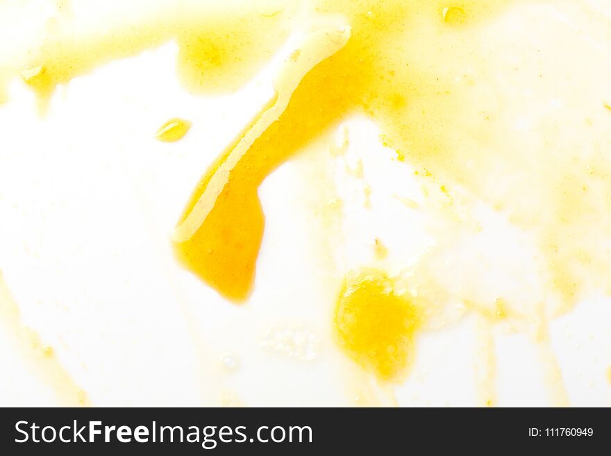 Smeared yellow jam on white. Abstract background.