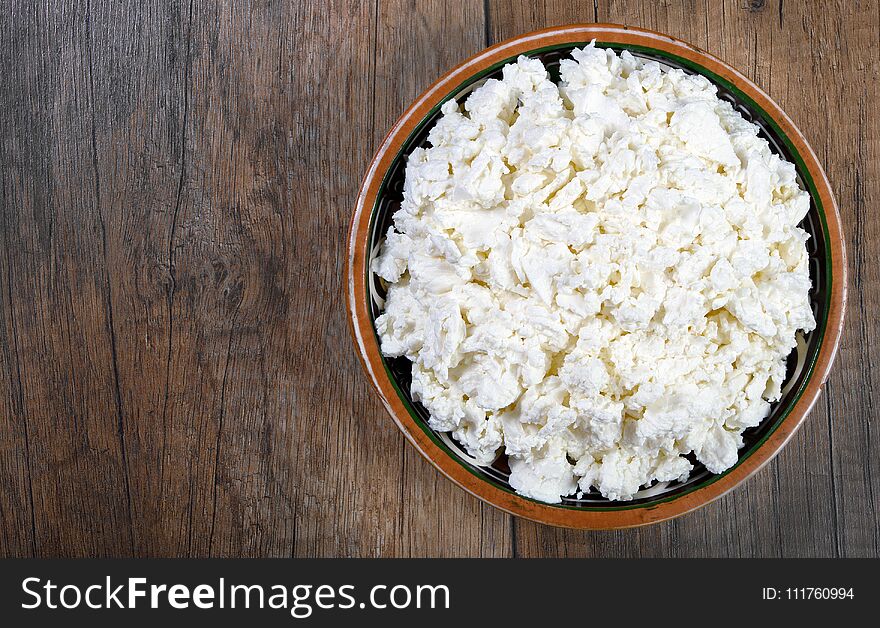 Homemade cottage cheese in a bowl on wooden table .close-up. Homemade cottage cheese in a bowl on wooden table .close-up