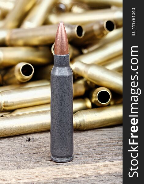 Close-up photo of bullet on the wooden table.