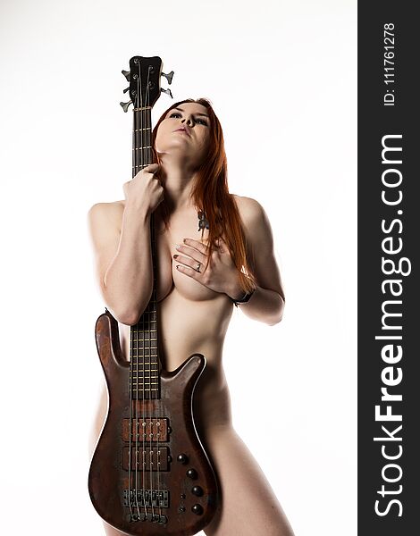 Nude rock woman holding electric guitar on a white background.