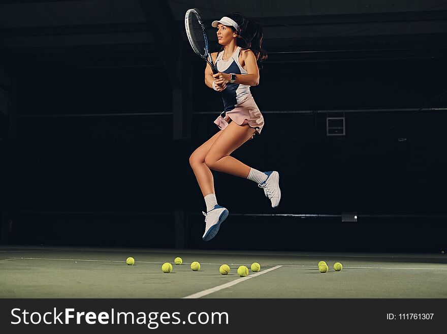 Female tennis player in a jump on a tennis court.