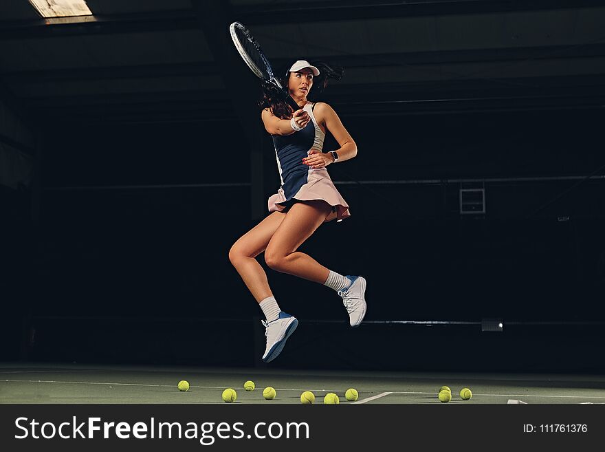 Female Tennis Player In A Jump On A Tennis Court.