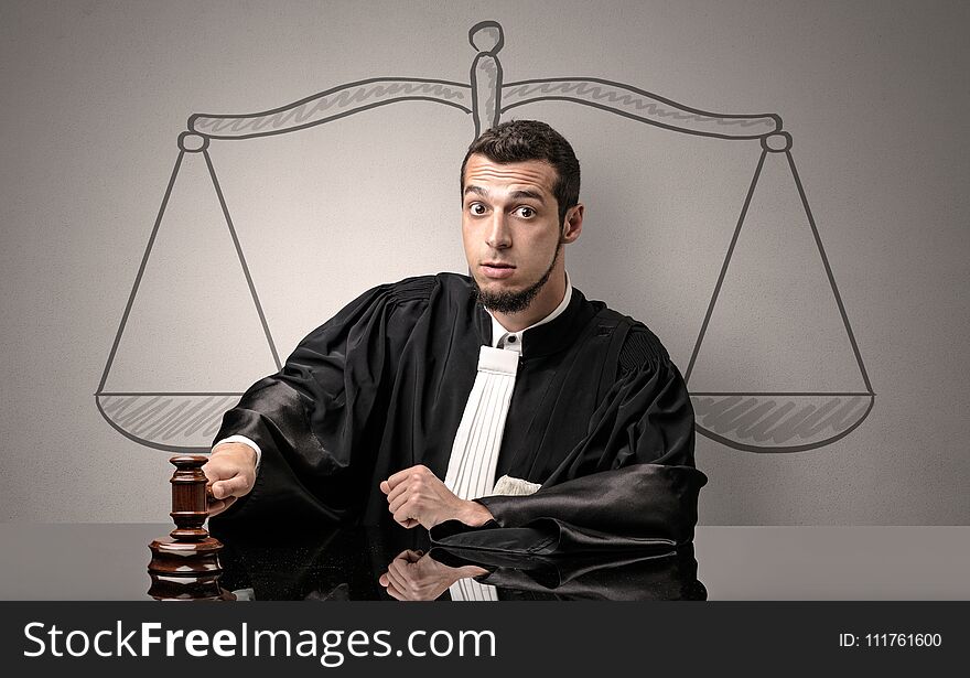 Young handsome judge in black gown making decision. Young handsome judge in black gown making decision