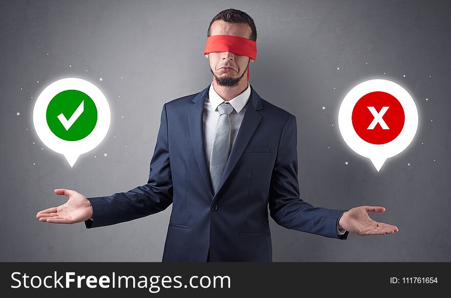 Blindfolded businessman with checked and x mark above his hand. Blindfolded businessman with checked and x mark above his hand