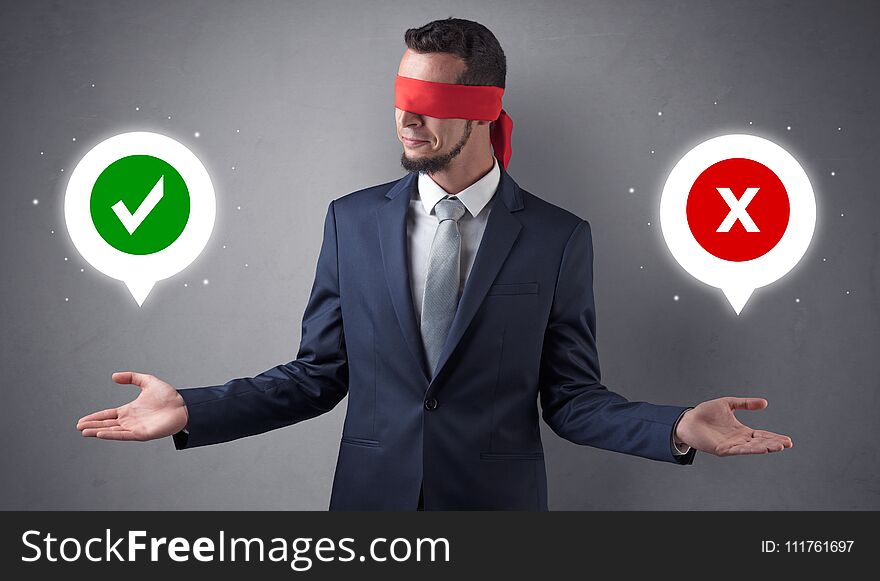 Blindfolded businessman with checked and x mark above his hand. Blindfolded businessman with checked and x mark above his hand
