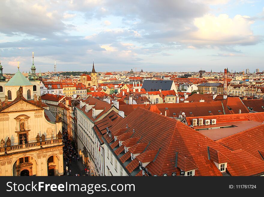 Panorama of Prague red roofs, people walking on the street