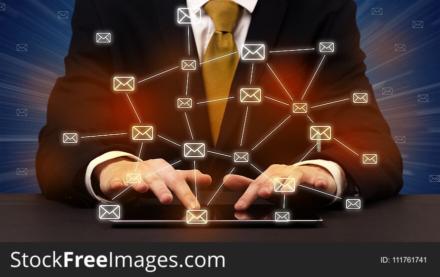 Businessman in suit typing with connected mail icons around. Businessman in suit typing with connected mail icons around