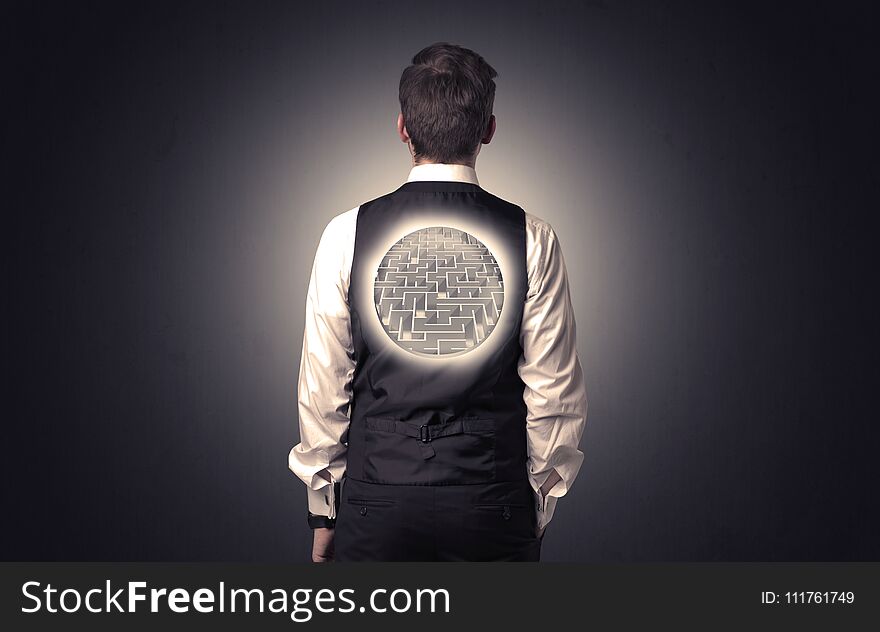 Businessman standing and thinking with maze graphic on his back. Businessman standing and thinking with maze graphic on his back