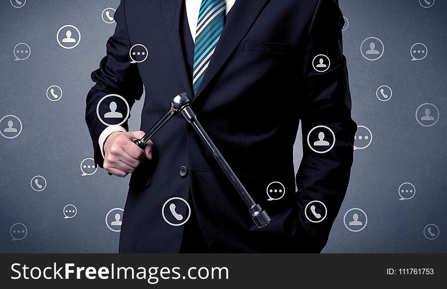 Thoughtful businesman holding tool with communication symbols around. Thoughtful businesman holding tool with communication symbols around