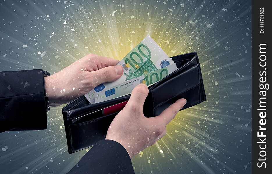 Businessman hand takes out dollar from wallet with fireworks and grungy background. Businessman hand takes out dollar from wallet with fireworks and grungy background