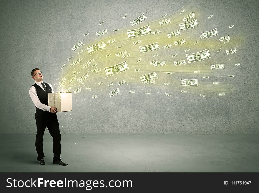 Successful young sales person making a lot of money concept illustrated with euro dollar bills flying out of a box held in his hand. Successful young sales person making a lot of money concept illustrated with euro dollar bills flying out of a box held in his hand.