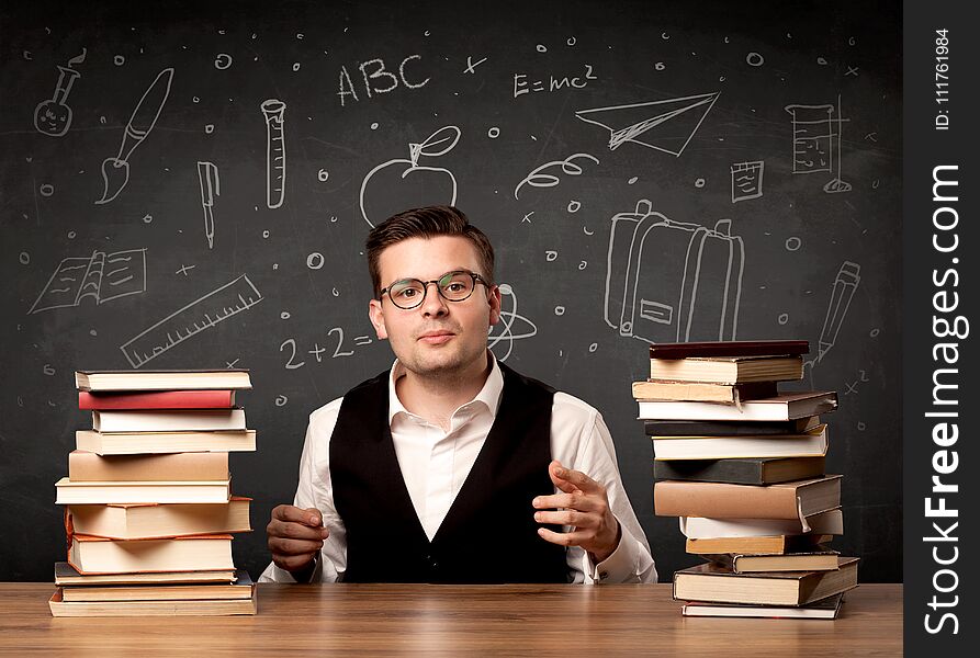 A passionate young teacher sitting at school desk with pile of books in front of blackboard drawn full of back to school items concept. A passionate young teacher sitting at school desk with pile of books in front of blackboard drawn full of back to school items concept.