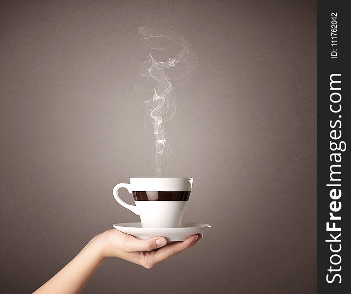 Young female hand holding steaming coffee cup. Young female hand holding steaming coffee cup