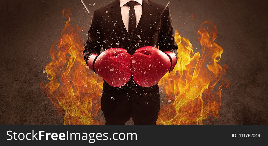 A strong sales person breaking something into pieces with red boxing gloves concept illustrated with glowing residue flying in the air. A strong sales person breaking something into pieces with red boxing gloves concept illustrated with glowing residue flying in the air.