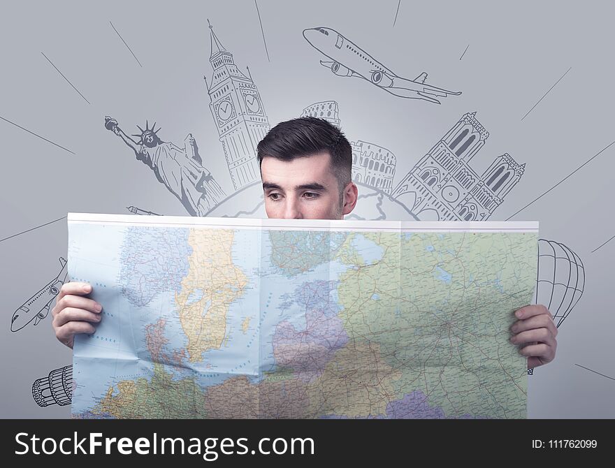 Handsome young man holding a map with famous sightseeing destinations above his head. Handsome young man holding a map with famous sightseeing destinations above his head