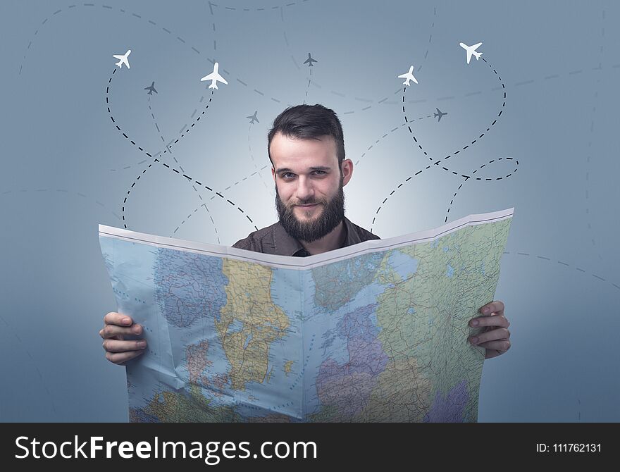 Handsome young man holding a map with little planes and their paths above him. Handsome young man holding a map with little planes and their paths above him