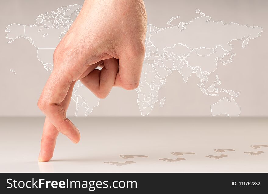 Female fingers walking with footsteps behind them and a world map in the background. Female fingers walking with footsteps behind them and a world map in the background