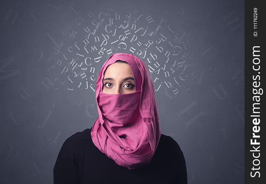 Young muslim woman wearing niqab with white alphabet letters above her head