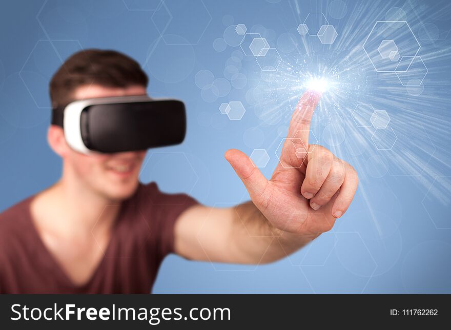 Young impressed man wearing virtual reality goggles with blue hexagons around him