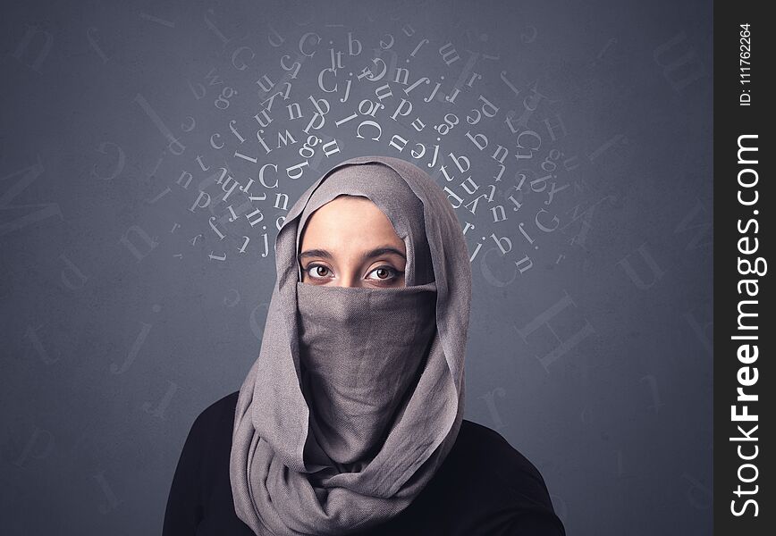 Young muslim woman wearing niqab with white alphabet letters above her head